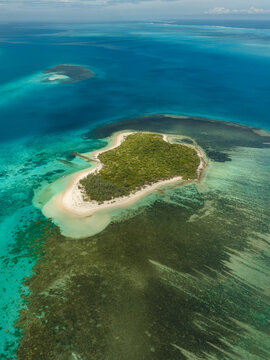 Aerial view of vibrant turquoise waters embrace lush green islands, contrasting with the intricate patterns of coral reefs below, Noumea, New Caledonia.