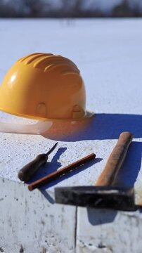 Construction tools and helmet on a cement foundation with iron rebar.