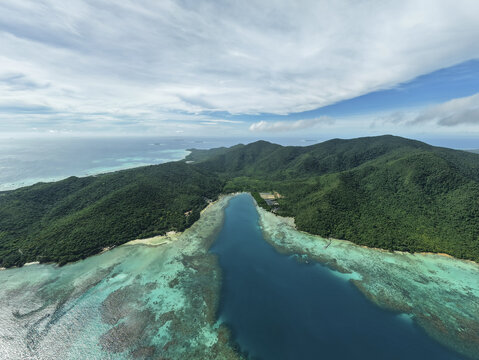 Aerial view of the lush green island meeting the turquoise sea in a stunning display of nature's artistry, Karimunjawa, Central Java, Indonesia.