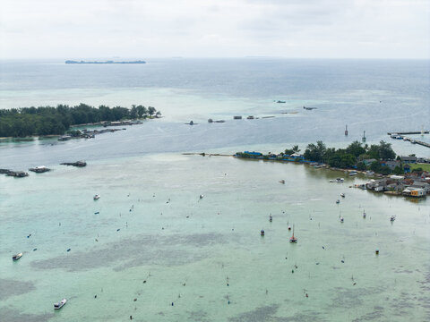 Aerial view of the turquoise waters embracing the small islands and coastal houses, a tranquil scene of Karimunjawa's beauty, Karimunjawa, Central Java, Indonesia.