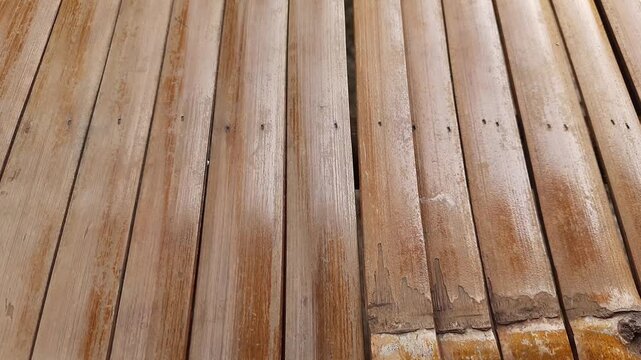 Weathered wooden planks subtly move, revealing natural light brown texture, rustic surface, and organic patterns in an abstract motion background video.