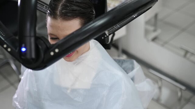 Professional hair treatment with climazone device in beauty salon, modern infrared equipment for coloring, restoration and care, female client during procedure, advanced haircare technology