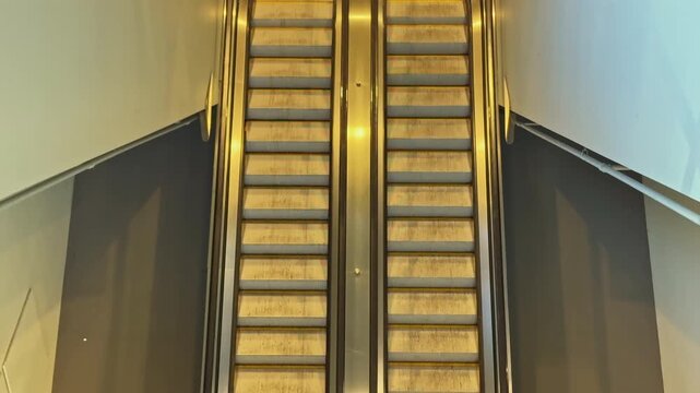 People use escalators to move between floors in a busy shopping center. The escalators are metal and wooden, positioned side by side for easy access.