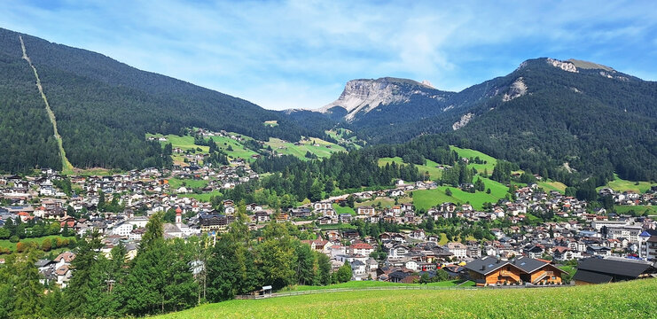Panorama of the town of Ortisei in summer with Mount Pich and Seceda in the background.