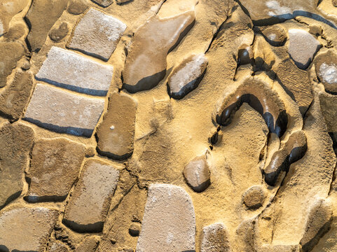 Aerial view of a mosaic stone pattern with earthy tones and textures creating a visually compelling abstract composition, [City Name], [State Name], [Country Name].