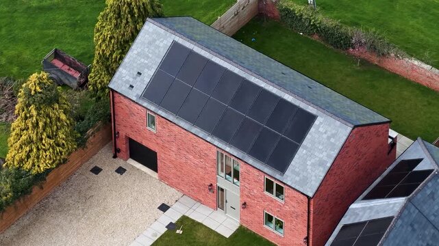 Aerial footage of a modern brick house in Bishop Monkton with solar panels gravel driveway garden, fenced outdoor space showing sustainable rural living in North Yorkshire village setting in spring