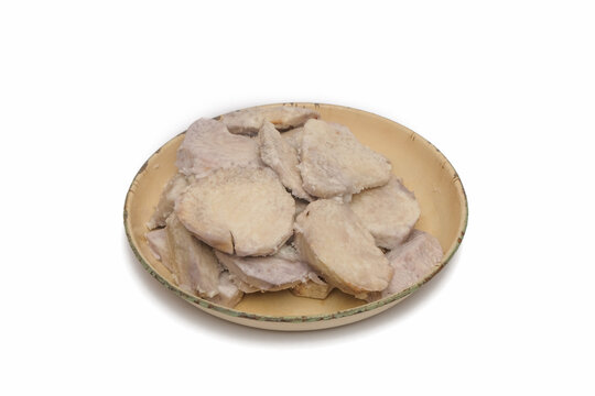 Boiled taro slices served on a vintage ceramic plate isolated on white background. Traditional Asian root vegetable, healthy steamed yam snack, or ingredient for tropical desserts