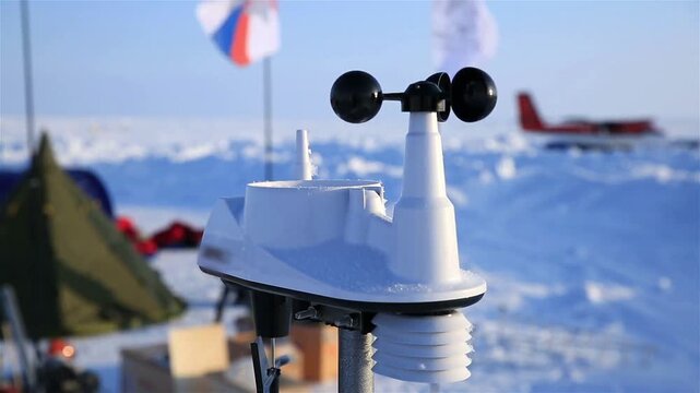 close up of a white automatic weather station anemometer operating in a snowy arctic research base camp environment