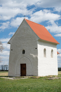 The Church of St. Margaret of Antioch in Kopcany, a historic pre-romanesque stone building with a red tiled roof standing in a rural spring landscape, Kopcany, Slovakia