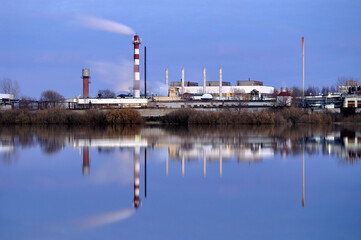 Obraz premium Industrial landscape, a glass fiber plant on the bank of the river in night time