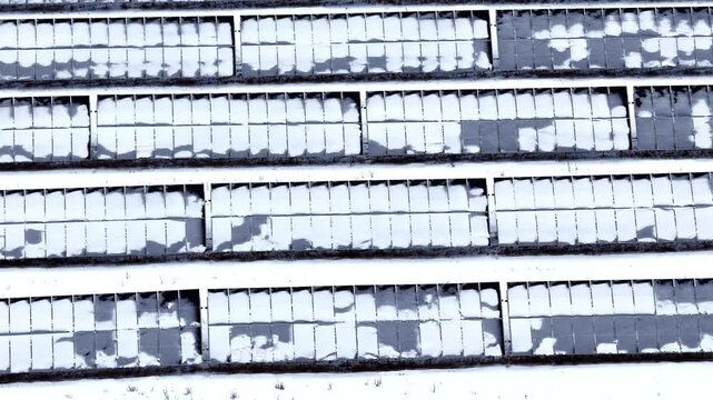 Solar farm with panels affected by snow, impacting energy generation capability