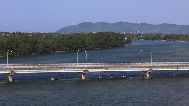 View of boats under Bu Lu Bridge, greenery and sea
