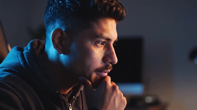 A man in a hoodie looking thoughtful.