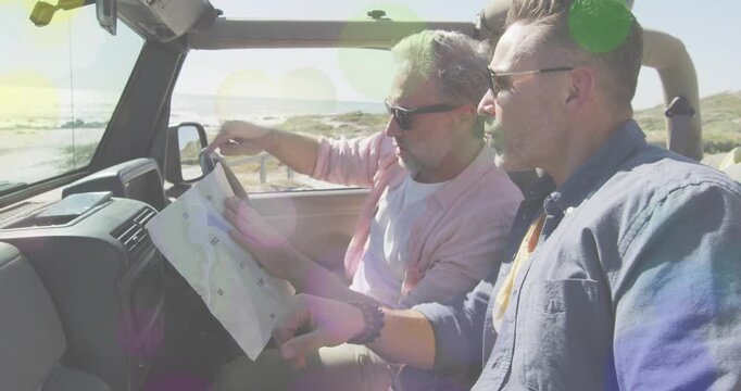 Passenger pointing at coastline and driver unfolding map in SUV, both matching route for travel