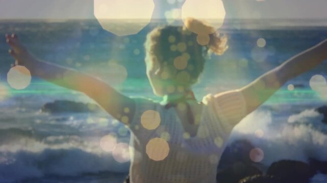 Woman standing back to camera on shore opening arms undoing hair overlays fading for marketing