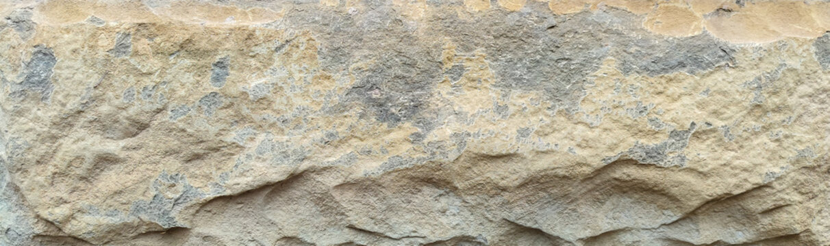 natural texture of rough weathered sandstone block with uneven surface and earthy colors for architectural background and construction design