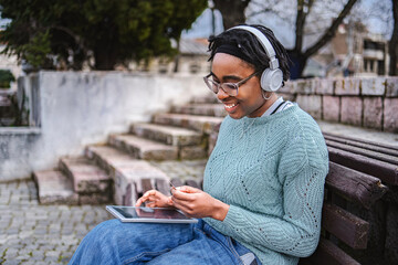 Obraz premium Young black woman online shopping using digital tablet and credit card