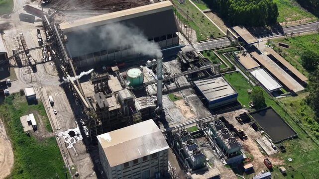 An aerial video view of an industrial facility with smokestacks and buildings