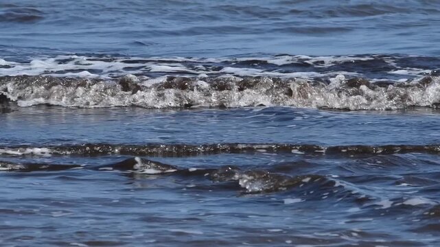 A polluted sea wave with dark foam from a spill, runoff of petroleum products from a petrochemical plant. Tuapse, oil spill at sea, oil pollution, disaster. War Iran.  Hormuz, Kharg.