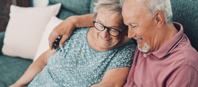 Senior couple sharing a warm, affectionate moment together on a couch at home