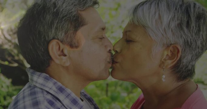Senior couple leaning in noses touching pausing resuming kissing showing love with pearls for ads