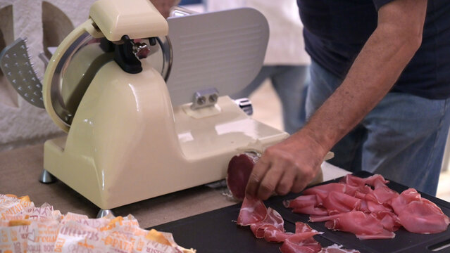 persona affetta il capocollo con una affettatrice professionale