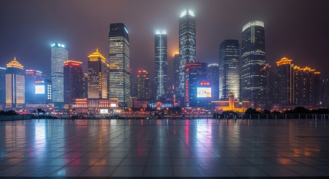 Modern city skyline with brightly lit skyscrapers and illuminated buildings reflecting on a large tiled plaza at nighttime.