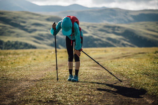Sports injured knee woman trail runner running in grassland