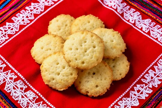 Traditional Paraguayan Chipa bread served on vibrant red ao poi embroidered fabric depicting authentic South American culinary heritage and culture