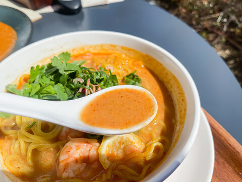 海老とネギが入った中華麺のラクサヌードル。スープのクローズアップ。