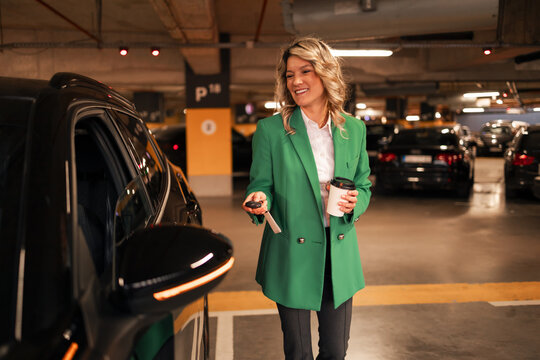 Businesswoman opening car door in underground parking garage