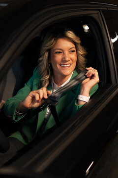 Smiling woman buckling seatbelt preparing for safe commute