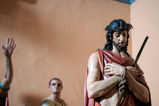 Escultura policromada de Jes&uacute;s como "Ecce Homo", con las manos atadas, corona de espinas y manto rojo. Una representaci&oacute;n dram&aacute;tica del arte sacro que evoca la pasi&oacute;n y el juicio de Cristo.