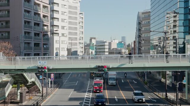 Tokyo Scene  :  Pedestrian Bridge and Traffic Lights with Arrow Signals at the Arterial Junction Surrounded by Towering Skyscrapers Under Clear Skies  |  Shibuya, Tokyo, Japan
