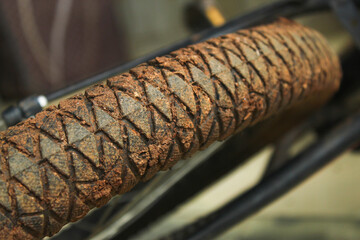 Close up of a dirty bicycle tire with a muddy tread pattern texture.