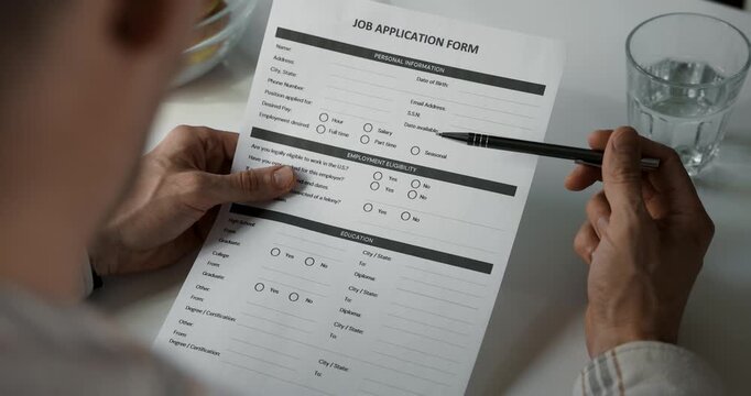 Filling out job application form at home with pen. Employment, hiring and career concept