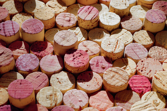 Colored wine corks background of red, rose, white wine, natural texture used bottle stoppers repeat pattern. Rustic aesthetic still life, wine branding, sommelier content, winery, winemaking concept.