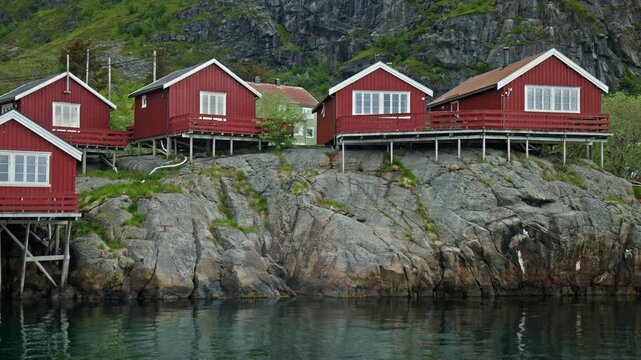 Stockfish museum building on stilts above water in Lofoten, Norway. Historic fishing industry site with reflections and coastal scenery.
