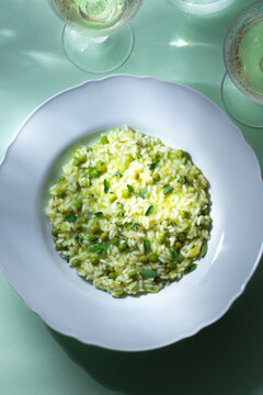 Light green spring risotto with peas and herbs, flowers. Spring menus