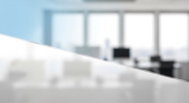 A blurred image with a slight blue tint and a diagonal line separating a bright office scene from a white space