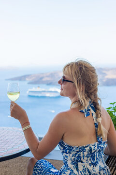 Woman with glass and wine in Greece in restaurant. Selective focus.