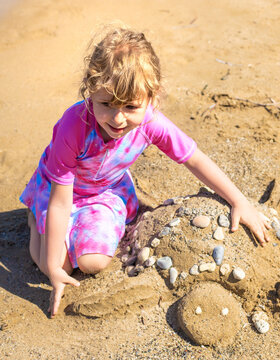 Children playing with sand on the beach. Selective focus.