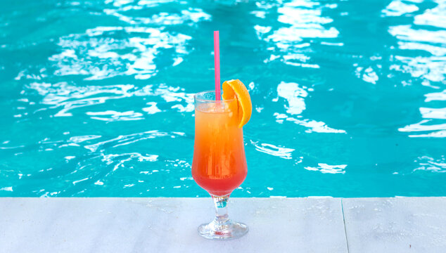 Woman in the pool with a cocktail. Selective focus.