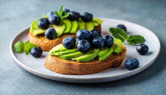 healthy avocado toast with mint and blueberries on a plate