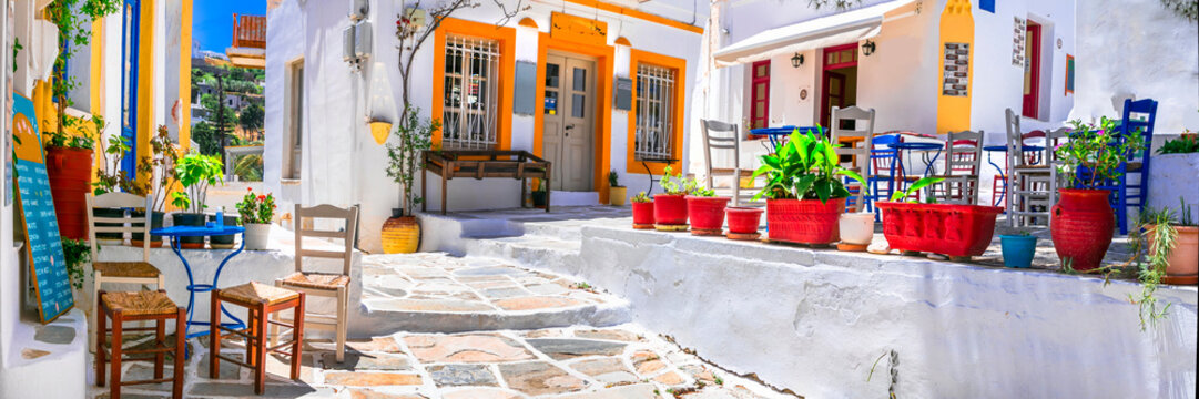 Paros Greece. Panorama 9k of Lefkes Village. Traditional Cycladic Street with White Stone Houses and Outdoor Cafe under Pine Trees with Colorful greek Chairs.  High Resolution World Print.