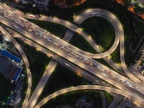 Symmetrical aerial view of Phap Van Cau Gie interchange with Ring Road 3 in Hanoi at night featuring glowing circular ramps, flowing traffic, and structured road network