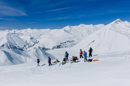 Freeride skiers climbing and descending Bidara peak in Gudauri on deep fresh powder snow, winter adventure in Georgia mountains. Backcountry freeride and skiing untouched powder in snowy mountains