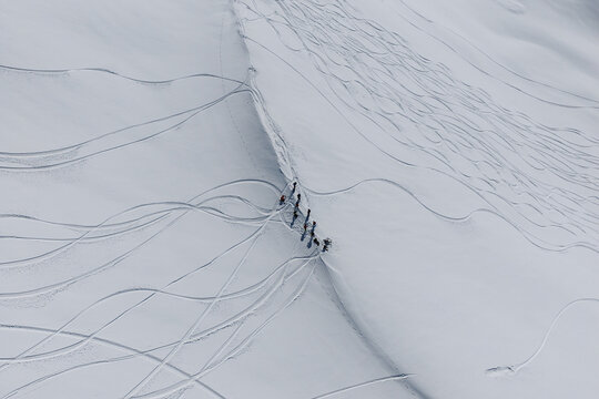 Freeride skiers climbing and descending Bidara peak in Gudauri on deep fresh powder snow, winter adventure in Georgia mountains. Backcountry freeride and skiing untouched powder in snowy mountains