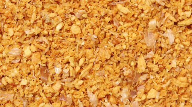Pile of crispy fried chopped garlic with skins rotating slowly, top view shot, thai ingredient