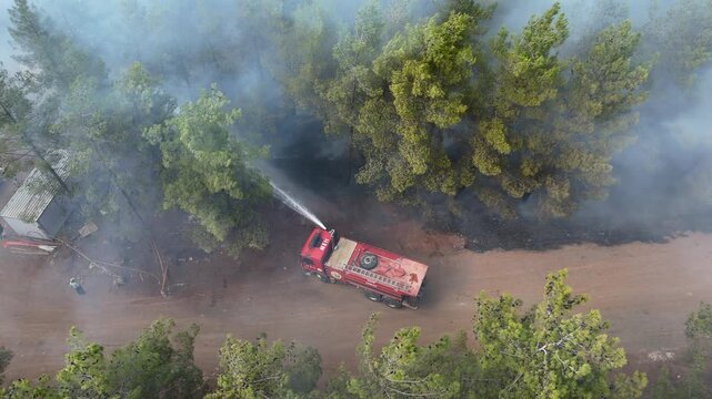 Aerial Drone View of Fire Truck Battling Wildfire in Forest, Climate Change and Environmental Destruction